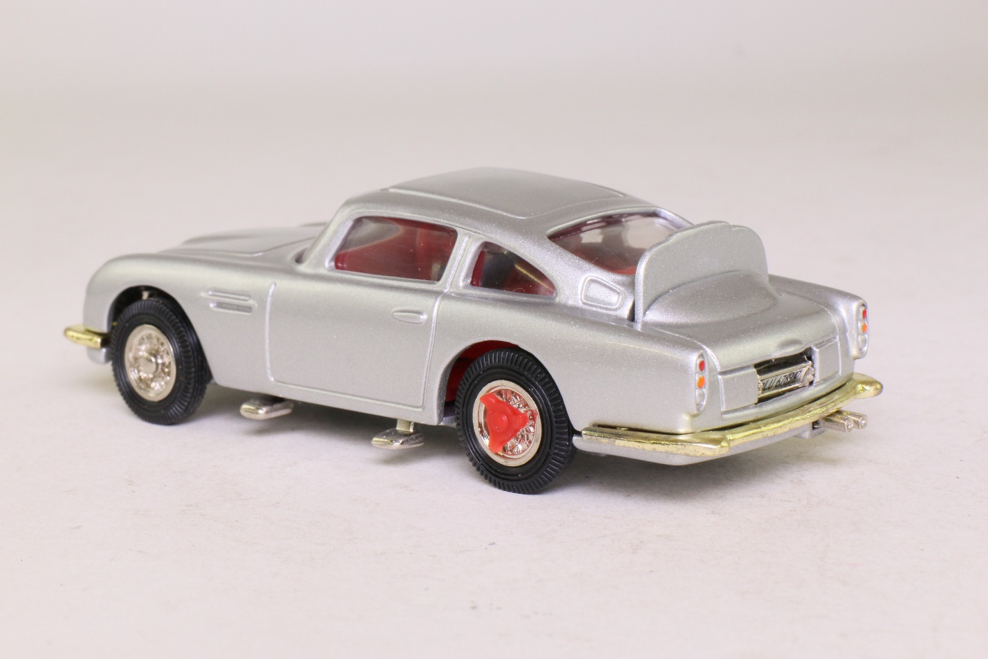 A silver car with red rims Description automatically generated with low confidence